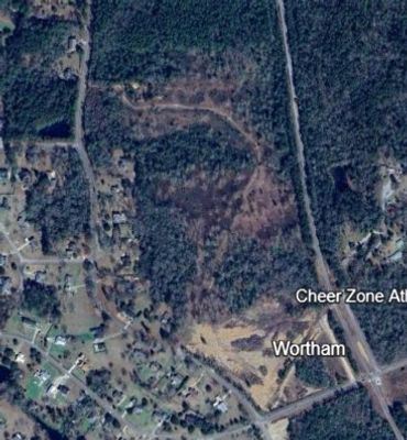 Aerial view of a semi-rural area with wooded land and scattered houses.