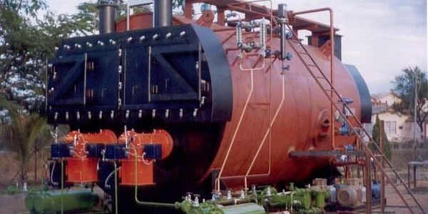 Large industrial boiler system with pipes and valves outdoors.