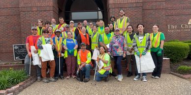 Group of people in safety vests posing outdoors.