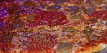 A close-up of a pepperoni pizza with some mushrooms.