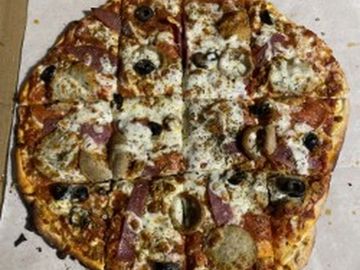 A pizza with various toppings and melted cheese.