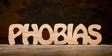 the word Phobias cut out of wood on  a wooden table brown background