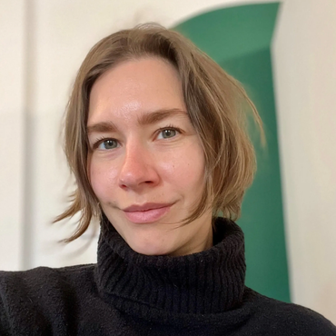Woman with short hair wearing a black turtleneck sweater.
