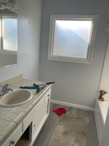Bathroom under renovation with tools and cloths on the floor.
