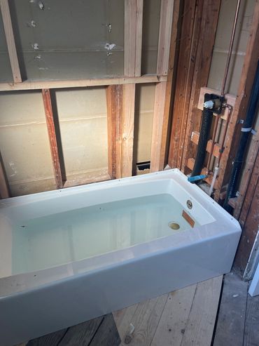 New bathtub installed in an unfinished bathroom.