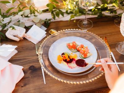 Elegant plated appetizer with colorful garnishes on a wooden table.