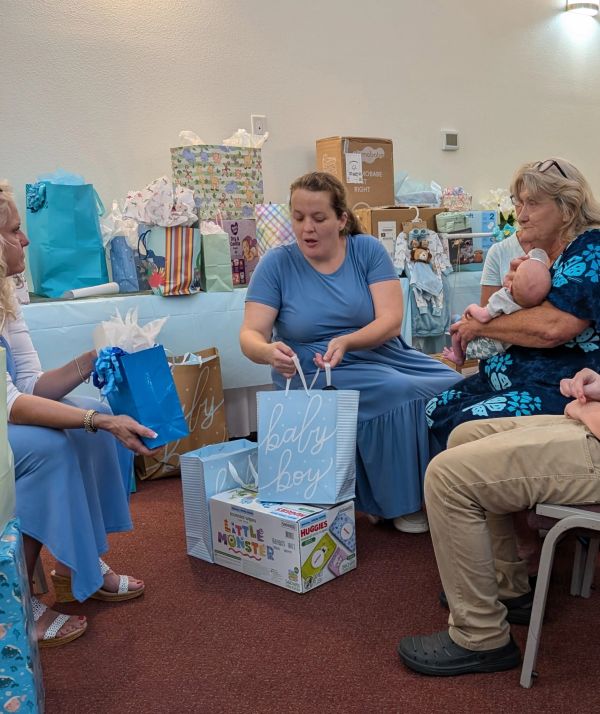 Women at a baby shower exchanging gifts.