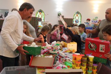People packing holiday gift boxes together.