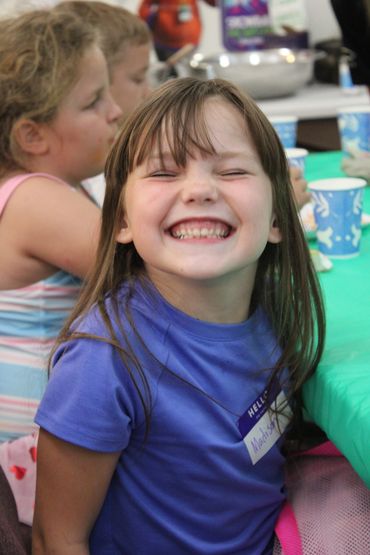 Smiling girl with blue shirt at a party.