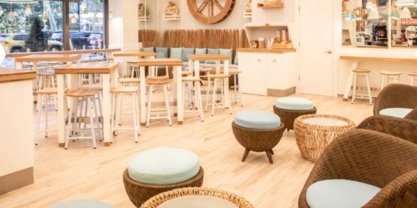 Bright, cozy cafe with wicker furniture and wooden tables.