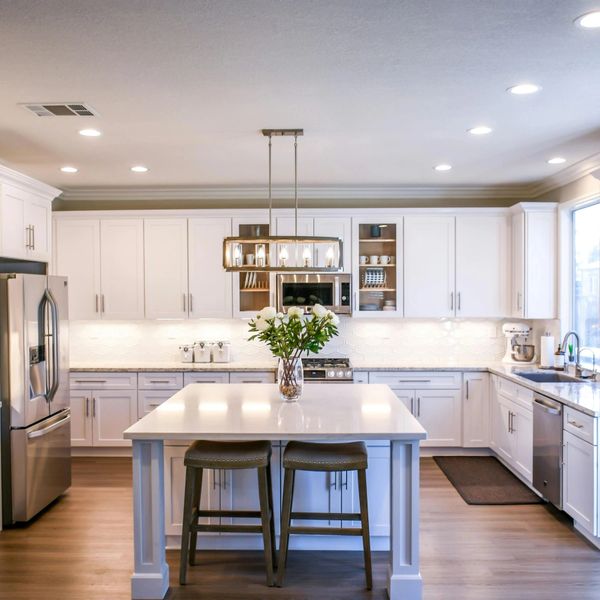 Bright modern kitchen with white cabinetry and a central island with seating.