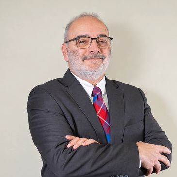 Confident man in suit with glasses.