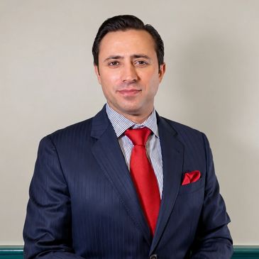 Man in a navy suit with a red tie.