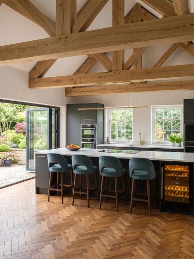 Modern kitchen with wooden beams and blue stools.