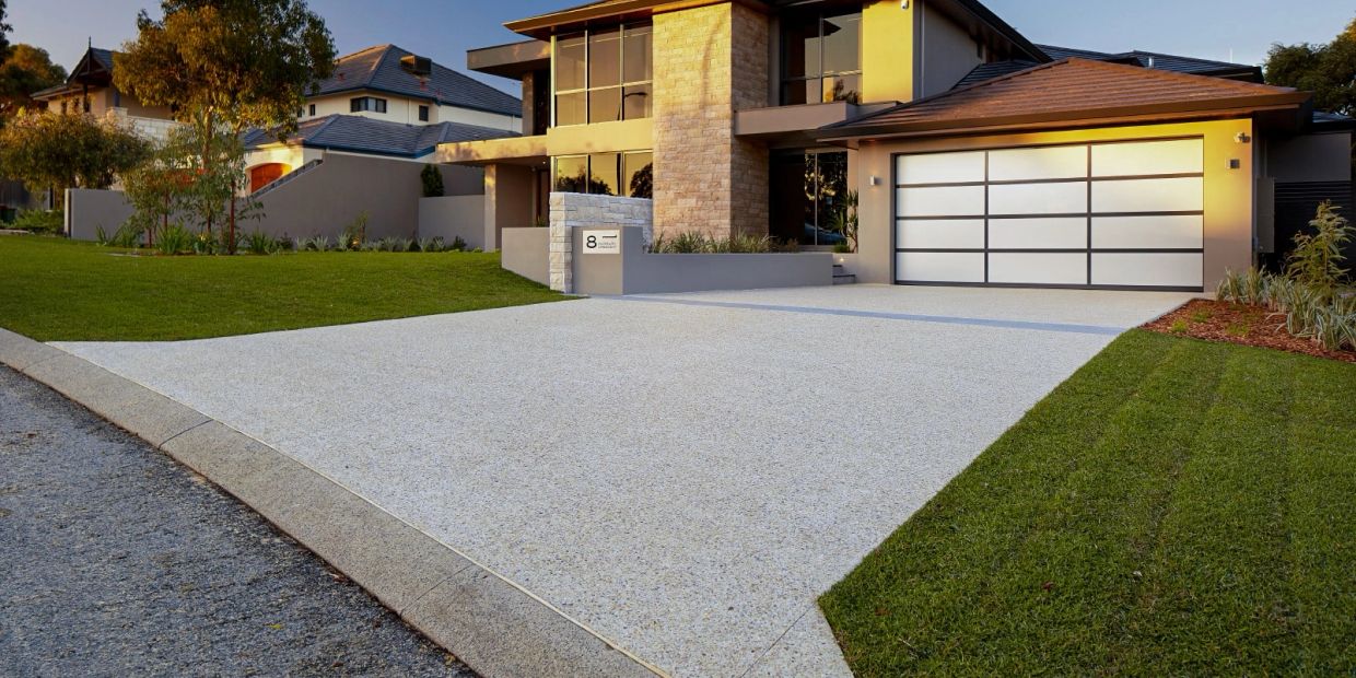 Modern house with a clean driveway and well-maintained lawn.