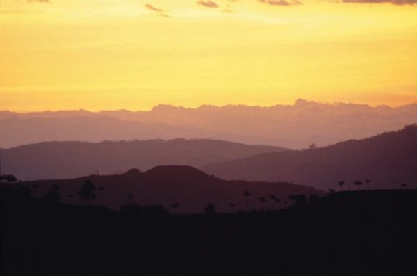 Atardecer con siluetas de colinas y montañas.