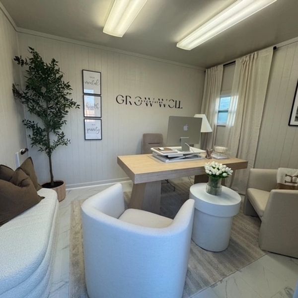 Modern office with wooden desk and comfortable seating.