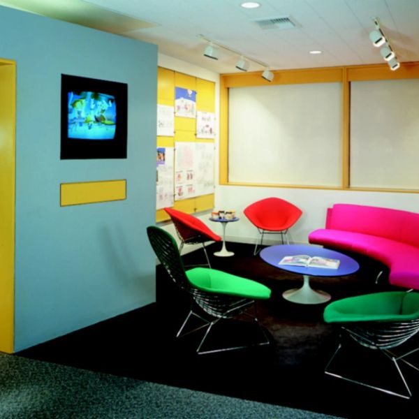 Vibrant, modern lounge with colorful chairs and a TV.
