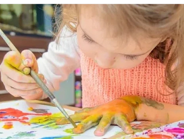 child painting her hands