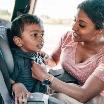 mother putting child in car seat