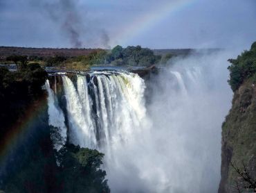 A waterfall with a rainbow arching over it.