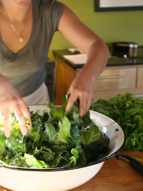 Tossing fresh salad in large white bowl for buffet dinner at Soul Food Farm in Vacaville, CA.