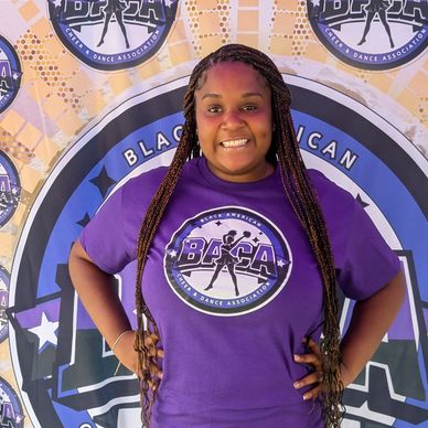 Smiling woman in a purple BACA shirt posing confidently.