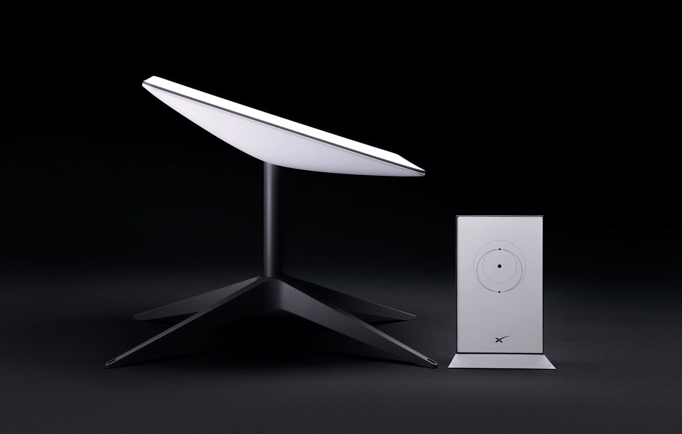 Sleek modern satellite dish and control unit on black background.