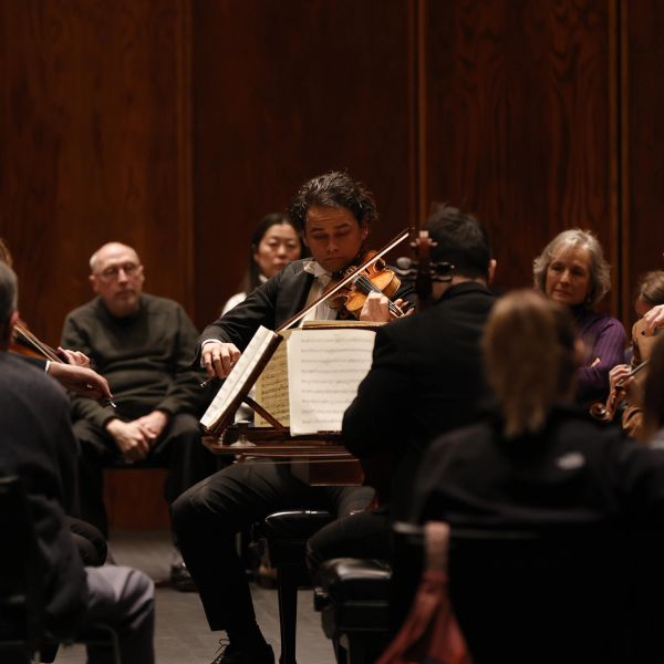 Violinist performing in front of an audience.