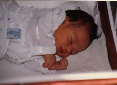 Newborn baby sleeping peacefully in a crib.
