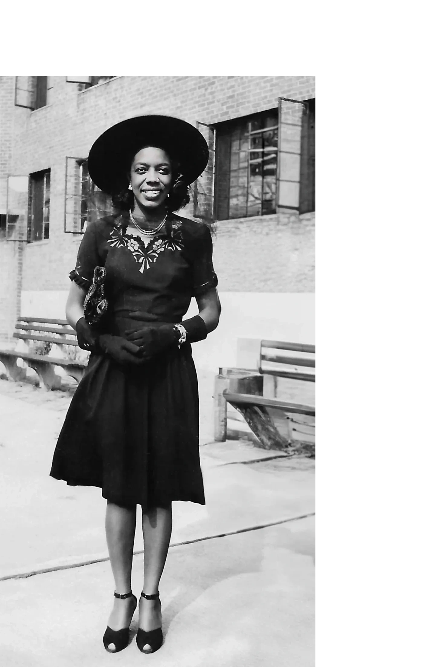 Kermit B. Hill in black hat and dress in front of Jersey City, NJ apartment 1944