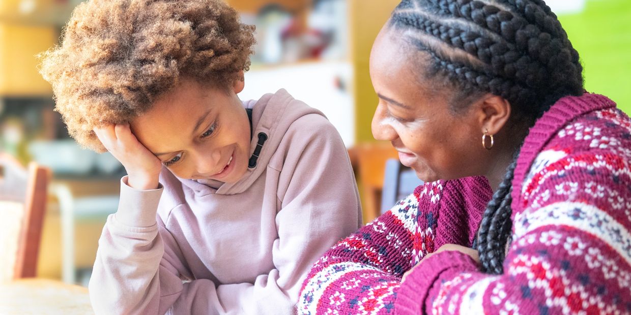 A woman and a child share a warm, joyful moment together indoors.