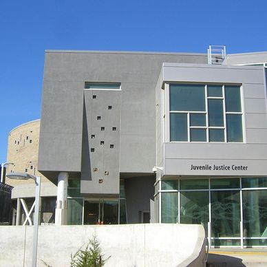 Modern Juvenile Justice Center building with geometric design under clear blue sky.