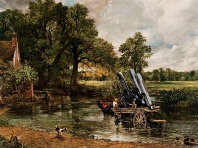 Two cannons on a wooden cart crossing a shallow river in a countryside scene.