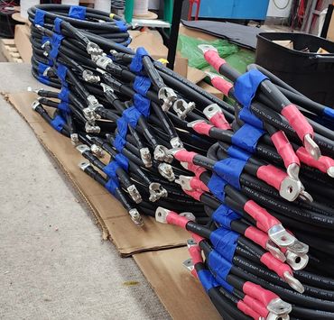 Stack of electrical cables with connectors organized on a table.