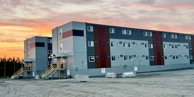 Modular building at sunset on a gravel lot.
