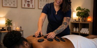 Woman receiving hot stone massage in spa.