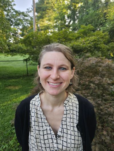 Smiling woman outdoors in a garden.