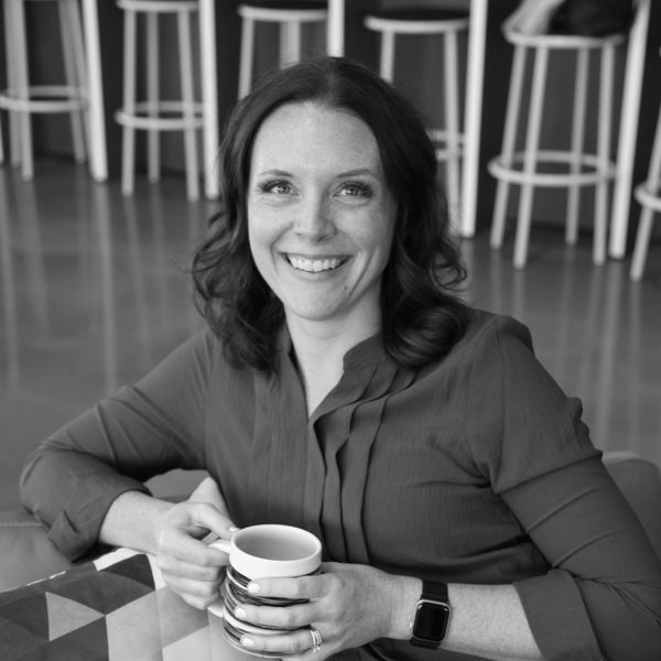 Smiling woman holding a coffee cup.