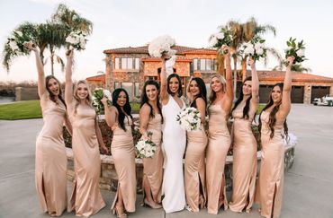 A bride and her bridesmaids in front of a fountain