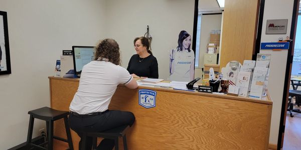Customer consulting an insurance agent at a Progressive office.