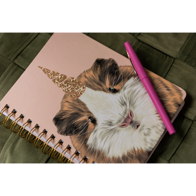 A pink notebook with a unicorn hamster on the front