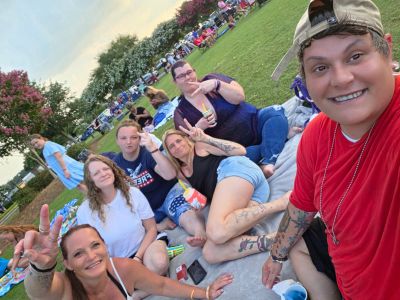 Group of friends enjoying an outdoor picnic on grass.