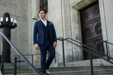 Jared wearing a three piece blue suit walking down the steps of the Supreme Court of Canada