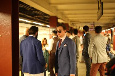Jared waiting on the subway in New York City wearing a three-piece suit.