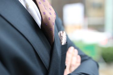 A detailed profile image of a tie, a pocket square, and a double-breasted jacket.