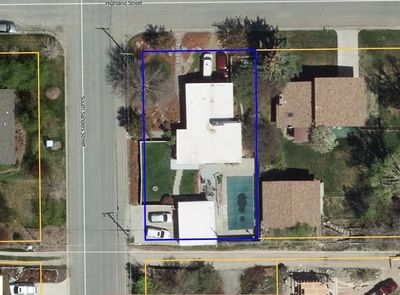 Aerial view of a residential property with a pool and vehicles.