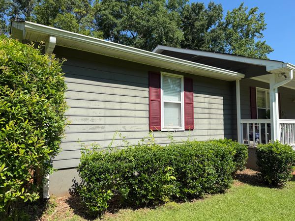 Home exterior with visible organic staining on siding before professional soft washing in Macon, GA.