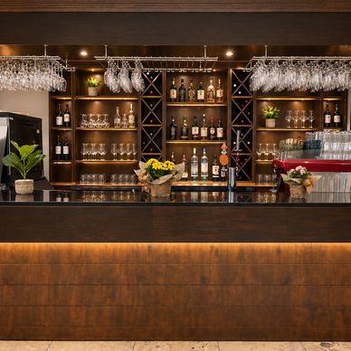Bar élégant avec étagères en bois et verres suspendus.