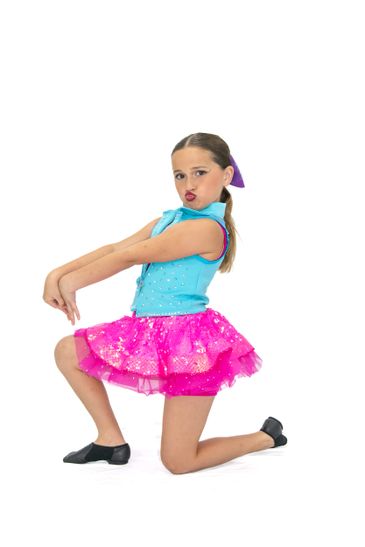 Young girl in colorful dance outfit striking a pose.